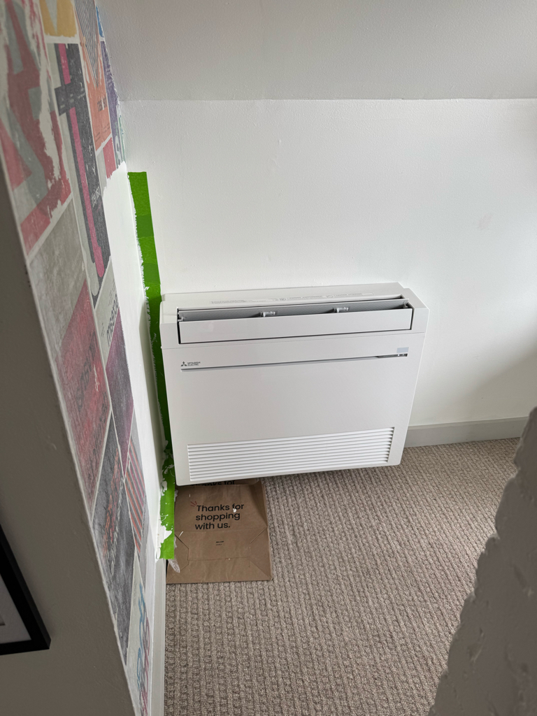 Mitsubishi floor-console heat pump indoor unit installed in a Bay Area room